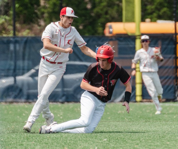 Tri-Valley junior Owen Miller (2) is tagged out by Holy...