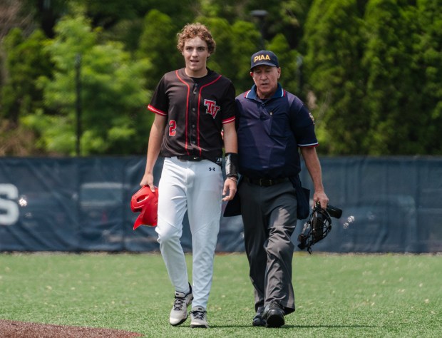 An umpire walks Tri-Valley junior Owen Miller (2) off the...
