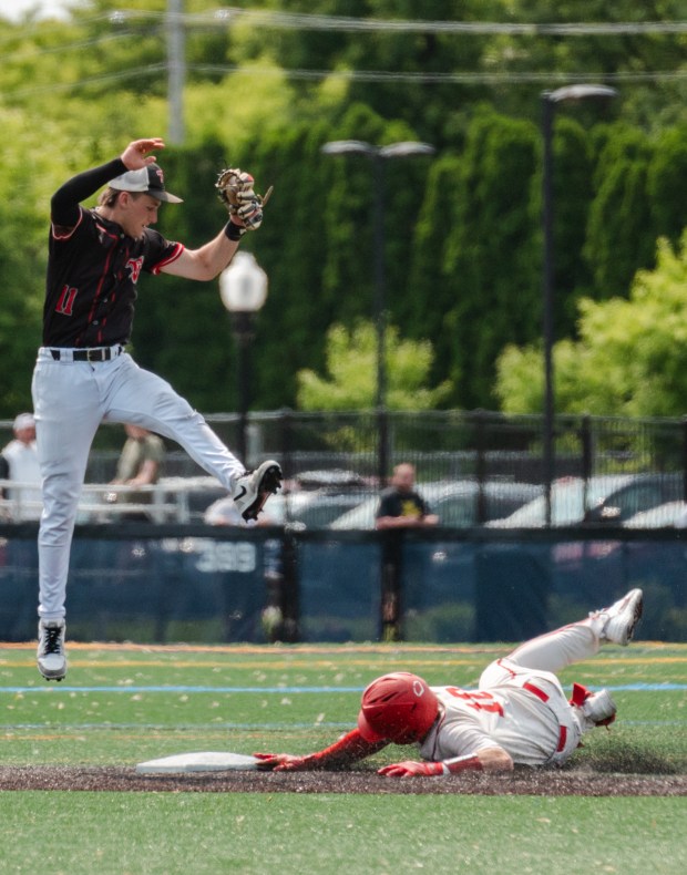 Tri-Valley junior Jason Stewart (11) jumps to secure the ball...