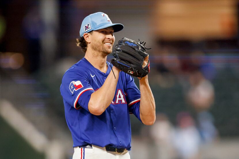 Texas Rangers starting pitcher Jacob deGrom (48) smiles before throwing a pitch during the...