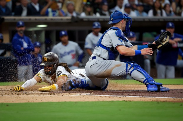 San Diego Padres' Fernando Tatis Jr. slides safely across home against Los Angeles Dodgers' Dalton Rushing during the third inning at Petco Park on Tuesday, June 10, 2025 in San Diego, CA. (Meg McLaughlin / The San Diego Union-Tribune)