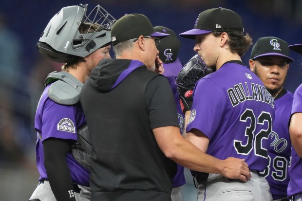 Colorado Rockies starting pitcher Chase Dollander (32) meets on the mound during the third inning of a baseball game against the Miami Marlins, Tuesday, June 3, 2025, in Miami. (AP Photo/Lynne Sladky)