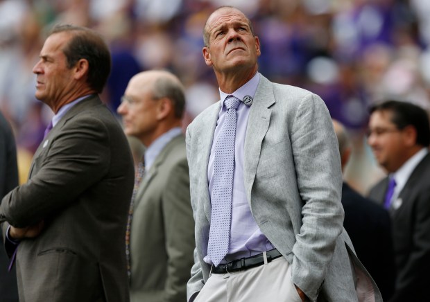 Colorado Rockies co-owner Charlie Monfort, front, joins his brother and co-owner, Dick, in surveying the crowd during a ceremony to retire the number of retired first baseman's Todd Helton before the Rockies host the Cincinnati Reds in a baseball game in Denver on Aug. 17, 2014. (AP Photo/David Zalubowski)