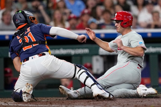 Philadelphia Phillies' Otto Kemp, right, is tagged out at home plate by Houston Astros catcher Yainer Diaz (21) during the fourth inning of a baseball game Tuesday, June 24, 2025, in Houston. (AP Photo/David J. Phillip)
