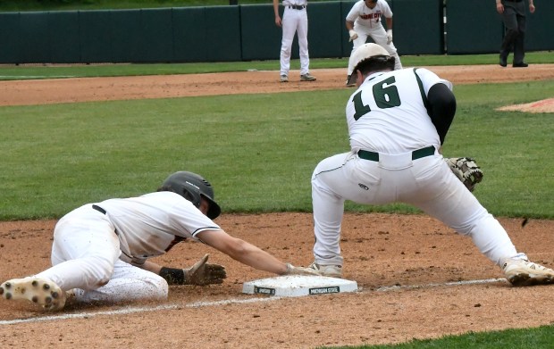 Marine City's Cooper Letson (left) slides in to third with...