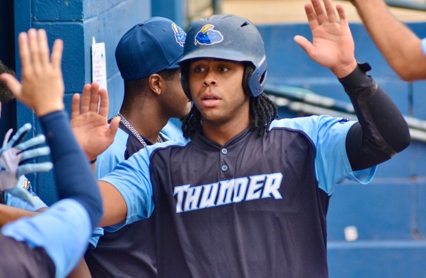 Thunder’s Carsten Sabathia is high-fived by teammates in the dugout...