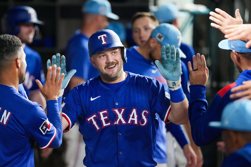 Texas Rangers first baseman Jake Burger celebrates with teammates after hitting a solo home...