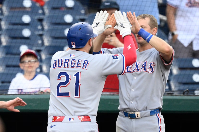 Texas Rangers' Jake Burger celebrates his home run with Josh Jung during the eighth inning...