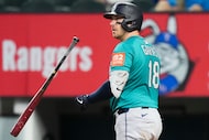 Seattle Mariners catcher Mitch Garver tosses his bat as he watches the flight of his two-run...