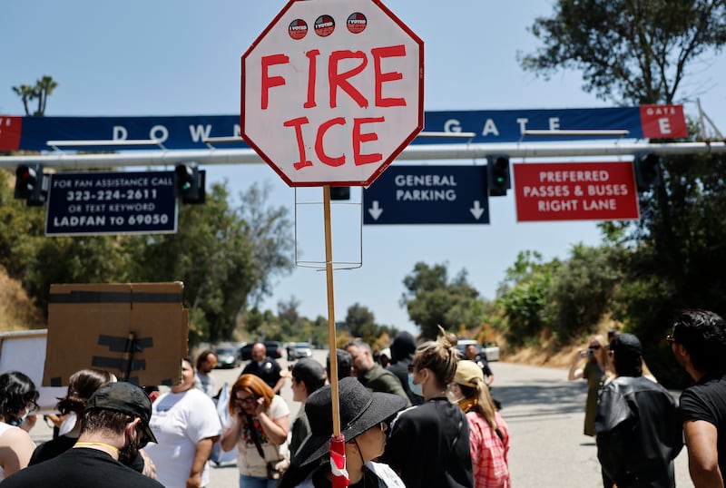 Protesters demonstrate not far from federal agents staged outside a gate of Dodger Stadium