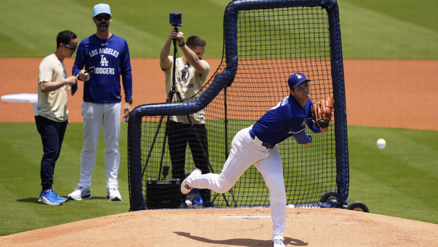 Los Angeles Dodgers' pitcher Shohei Ohtani, center, throws live batting practice as pitching coach ...
