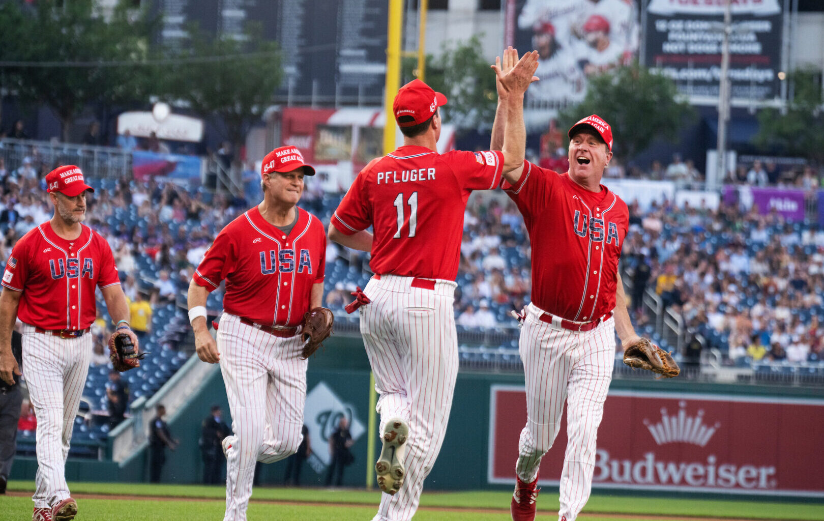 Rep. August Pfluger, R-Texas, is congratulated by Sen. Eric Schmitt, R-Mo., after a play in the first inning of the Congressional Baseball Game at Nationals Park on Wednesday.