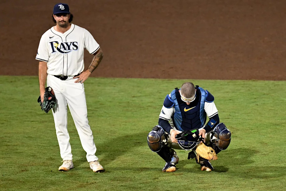 Tampa Bay Rays catcher Danny Jansen (19) and relief pitcher Connor Seabold (41) look on as pitcher Hunter Bigge (43) gets medical attention after getting hit in the face by a foul ball.