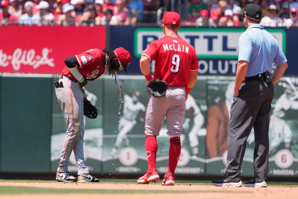 Reds shortstop Elly De La Cruz (l.) vomits during a game against the Cardinals in St. Louis on June 21, 2025.