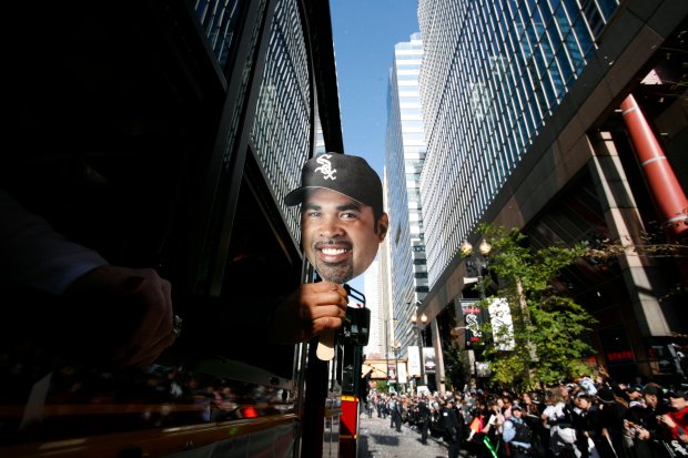 One of the many masks of Chicago White Sox manager Ozzie Guillén passed out by the City of Chicago, pops out as one of the double-decker buses as it makes its way down the parade route celebrating the team's World Series victory. In the Loop on Oct. 28, 2005. (José Moré/Chicago Tribune)