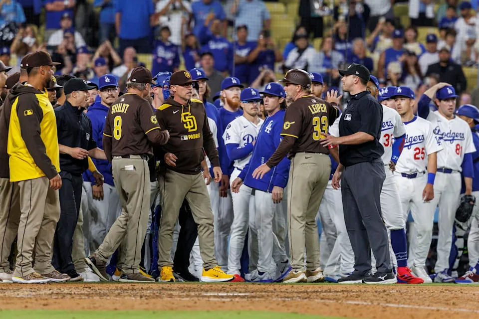 Padres and Dodgers players stand on the field after the benches clear in the ninth inning.