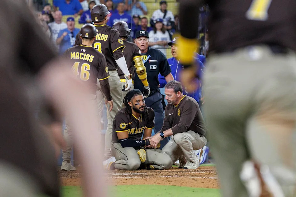 The benches clear as Padres batter Fernando Tatis Jr. is assisted by a team trainer after being hit on the hand by a pitch.