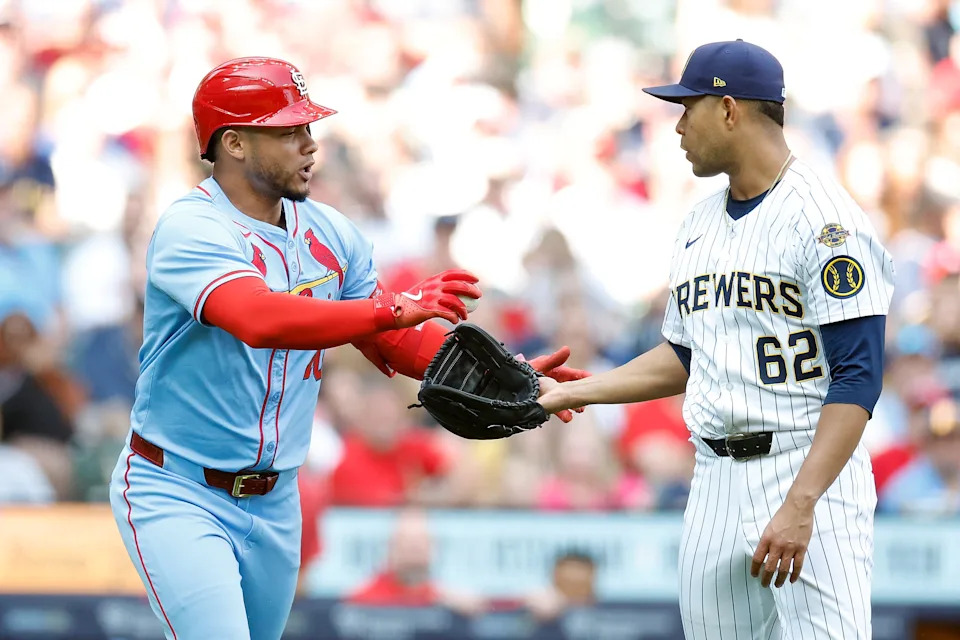 MILWAUKEE, WISCONSIN - JUNE 14: Willson Contreras #40 of the St. Louis Cardinals hands the ball to Jose Quintana #62 of the Milwaukee Brewers after being hit by a pitch in the fifth inning at American Family Field on June 14, 2025 in Milwaukee, Wisconsin. (Photo by John Fisher/Getty Images)