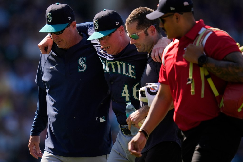 Mariners pitcher Trent Thornton (46) is helped off the field after suffering from heat exhaustion during a game against the Cubs in Chicago on June 21, 2025.