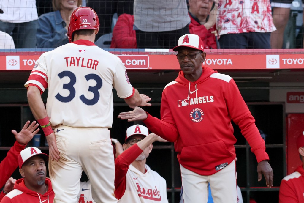 Los Angeles Angels player Chris Taylor high-fiving manager Ron Washington.