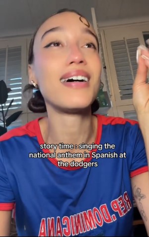 Woman in Dodgers jersey tearfully recounts singing the national anthem in Spanish.