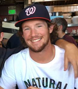 Man wearing a Washington Nationals baseball cap and white shirt.