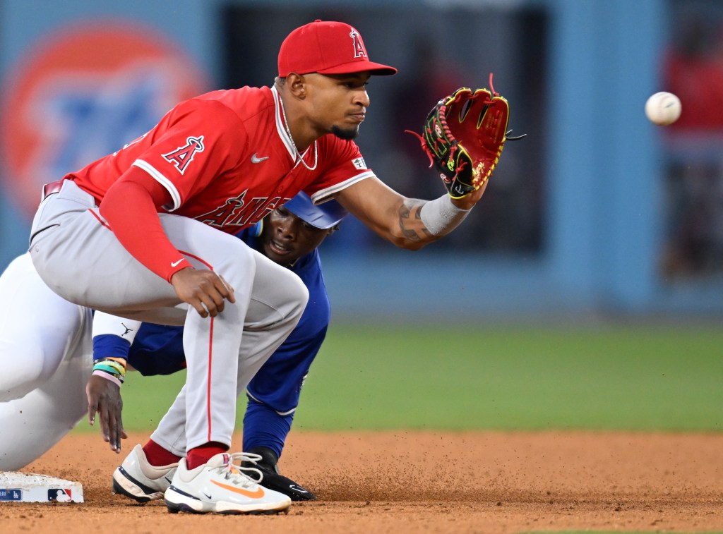 Baseball player stealing second base.