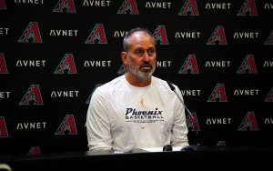 Diamonbacks manager Torey Lovullo sits at stand with Diamondbacks backdrop