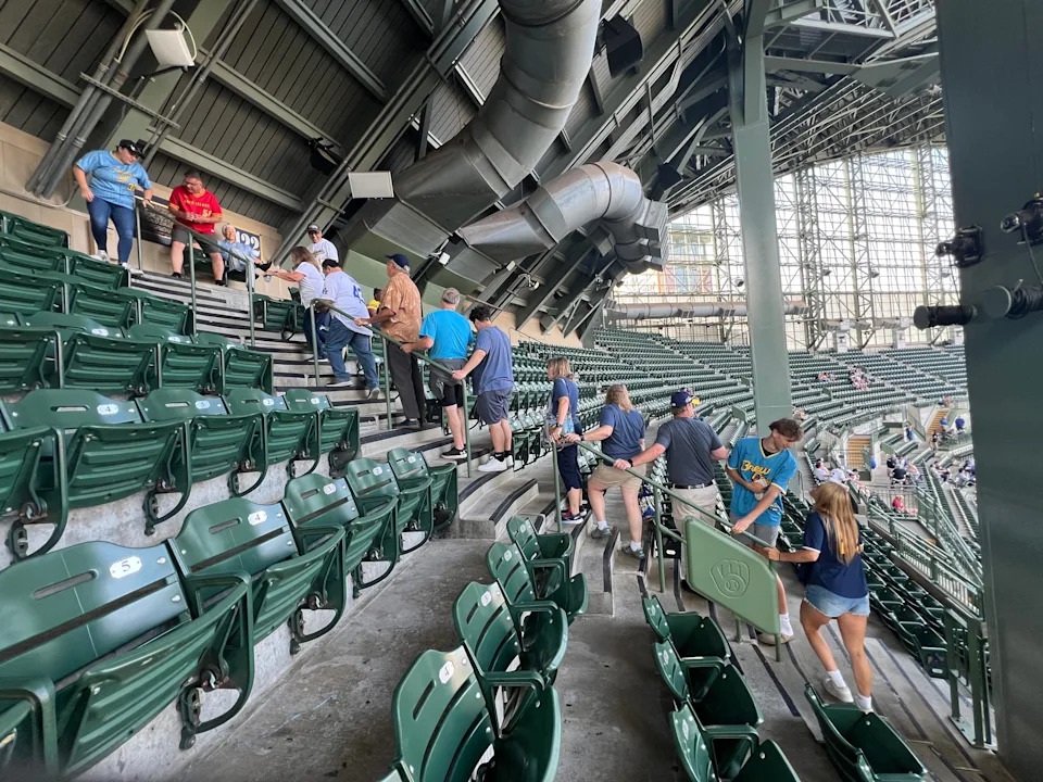 Fans lined up to take photos in the Bob Uecker seats at American Family Field before the Milwaukee Brewers game.