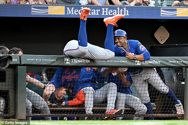 Brett Baty flips over the dugout railing after catching a foul ball from Jackson Holliday