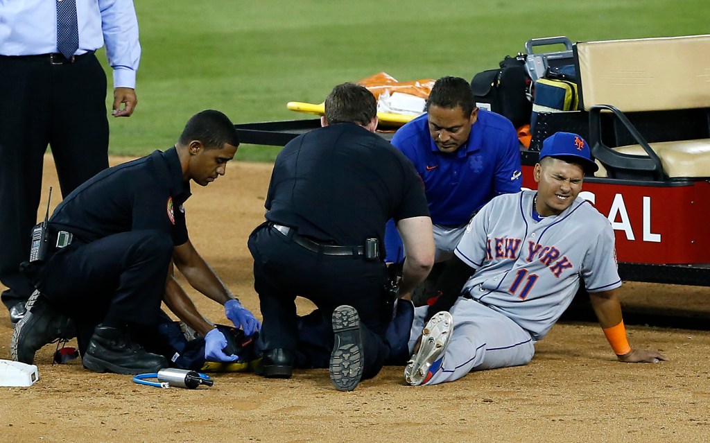  Ruben Tejada #11 grimaces as he is attended to after injuring his leg after getting upended by Chase Utley #26 in the 7th inning.