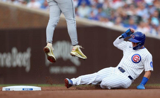 Chicago Cubs designated hitter Seiya Suzuki advances to second base as Cleveland Guardians shortstop Brayan Rocchio leaps for a high throw from home plate in the first inning of a game at Wrigley Field in Chicago on July 2, 2025. (Chris Sweda/Chicago Tribune)