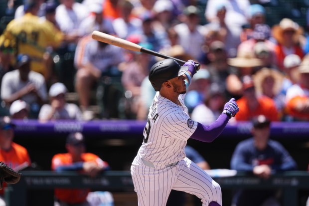 Colorado Rockies' Thairo Estrada follows the flight of his two-run home run off Houston Astros starting pitcher Brandon Walter in the first inning of a baseball game Thursday, July 3, 2025, in Denver. (AP Photo/David Zalubowski)
