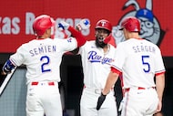 Texas Rangers second baseman Marcus Semien celebrates with outfielder Adolis García and...