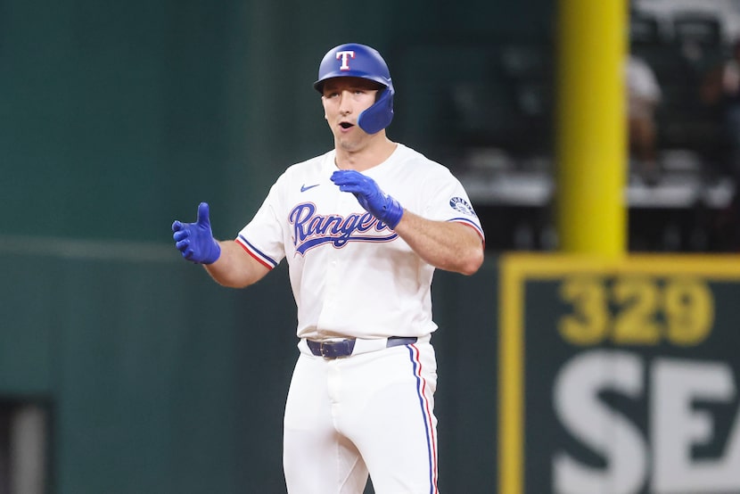 Texas Rangers Wyatt Langford cheers scoring a double during the seventh inning of a baseball...
