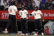 Texas Rangers' Cody Freeman (39) celebrates with Josh Smith (8) and Marcus Semien (2) after...