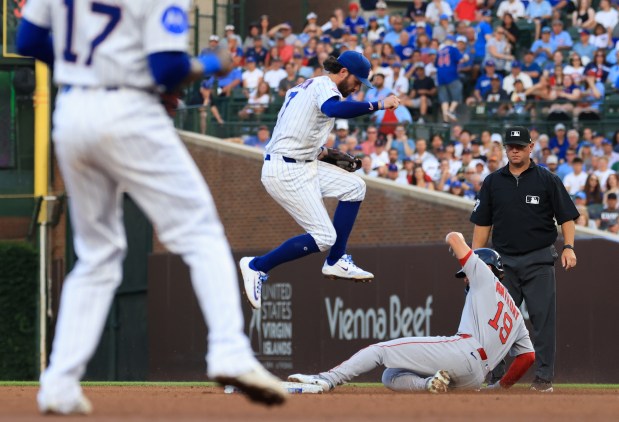 Cubs shortstop Dansby Swanson jumps over Red Sox right fielder Roman Anthony on a fielder's choice in the fourth inning on July 19, 2025, at Wrigley Field. (John J. Kim/Chicago Tribune)