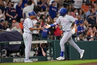 Texas Rangers' Kyle Higashioka, right, celebrates with third base coach Tony Beasley (27)...