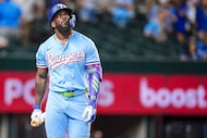 Texas Rangers outfielder Adolis García heads to the dugout after striking out to end a 2-1...