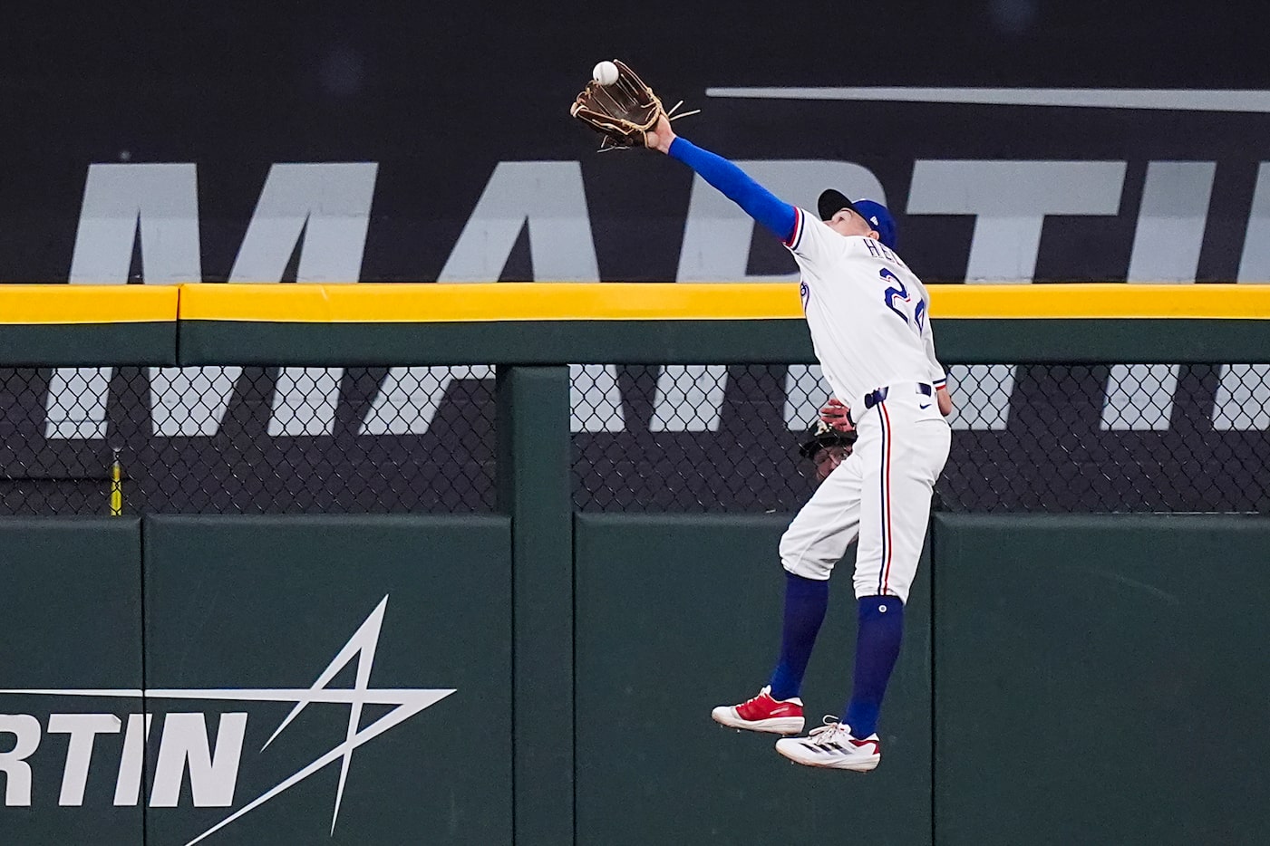 Texas Rangers outfielder Michael Helman (24) makes a leaping catch on a ball off the bat of...