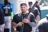 Arizona Diamondbacks' Josh Naylor walks in the dugout with his bat during the ninth inning...