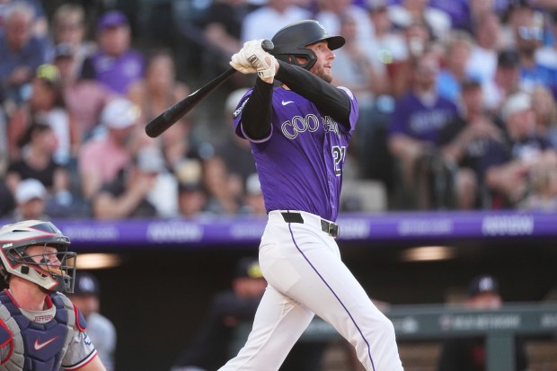 Colorado Rockies' Ryan McMahon follows the flight of his two-run home run off Minnesota Twins starting pitcher Zebby Matthews in the third inning of a baseball game Saturday, July 19, 2025, in Denver. (AP Photo/David Zalubowski)