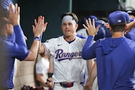 Texas Rangers outfielder Sam Haggerty gets congratulated by his teammates after scoring a...