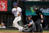Texas Rangers' Marcus Semien follows through on a run-scoring single as Atlanta Braves'...