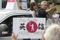 Baseball Hall of Fame inductee Ichiro Suzuki, right, and his wife Yumiko Suzuki smile during the Baseball Hall of Fame Parade of Legends in Cooperstown, N.Y., July 26, 2025. (AP Photo/Seth Wenig)