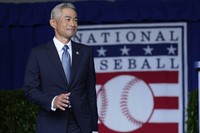 Baseball Hall of Fame inductee Ichiro Suzuki waves as he arrives on stage during the National Baseball Hall of Fame induction ceremony in Cooperstown, N.Y., July 27, 2025. (AP Photo/Seth Wenig)