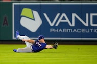 Texas Rangers center fielder Wyatt Langford can't handle a ball hit for an RBI double by Los...