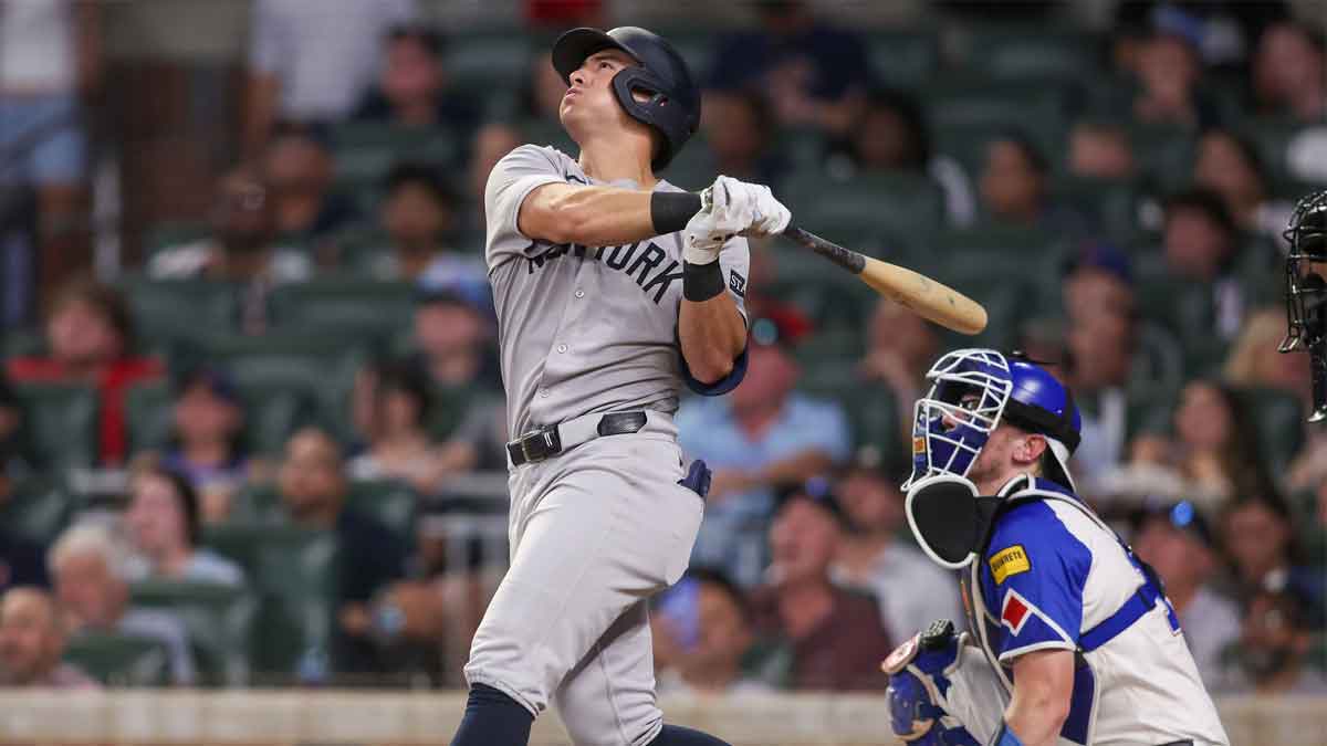 New York Yankees shortstop Anthony Volpe (11) drives in a run on a sacrifice fly against the Atlanta Braves in the sixth inning at Truist Park.