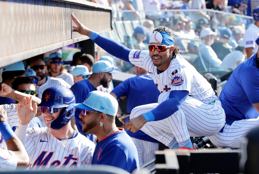 New York Mets player reaching for the dugout railing.