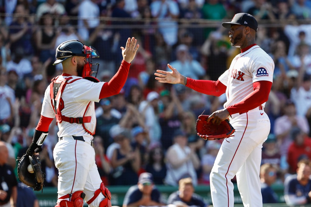 A baseball catcher and pitcher high-five.